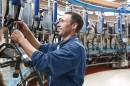 un addetto alla mungitura in un moderno allevamento zootecnico