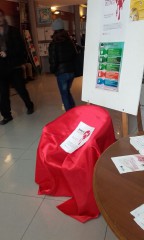 All'ingresso della Cisl di Brescia una sedia con il drappo rosso della campagna "posto occupato"